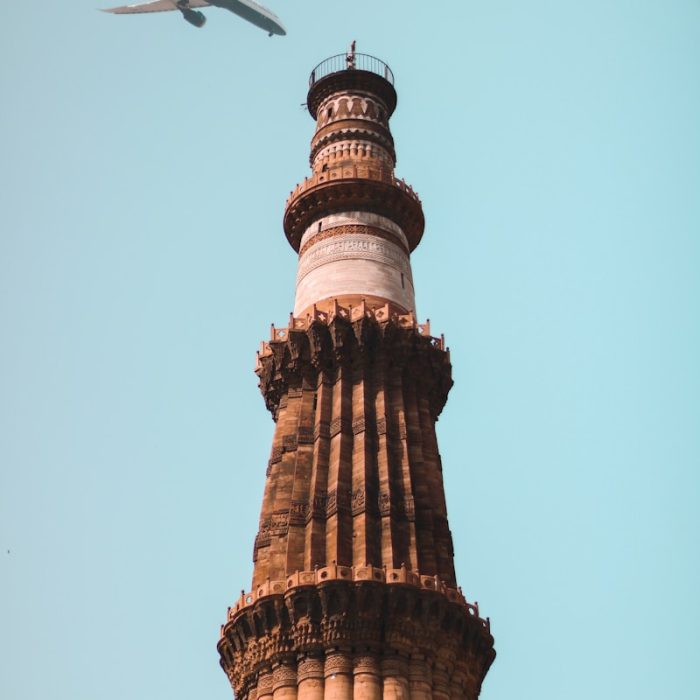 Delhi 4 an airplane is flying over a tall tower